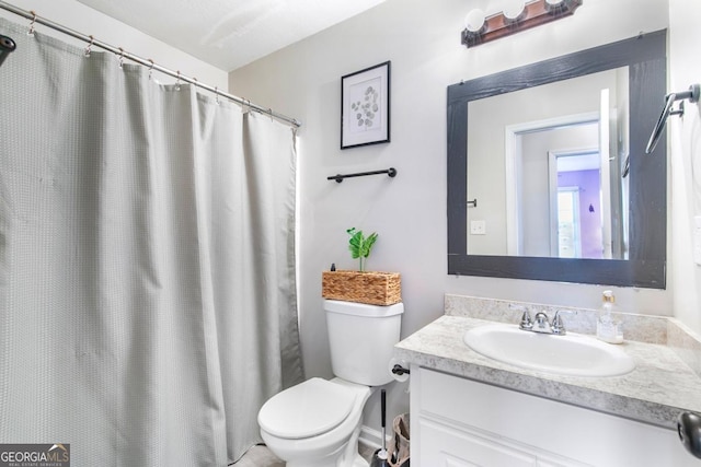 bathroom featuring curtained shower, toilet, and vanity
