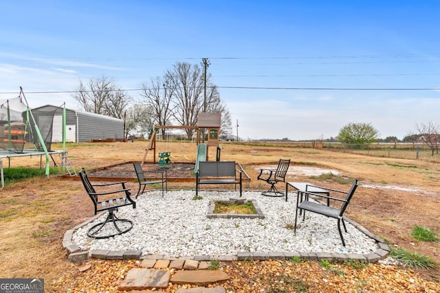 view of yard with a patio, a trampoline, an outbuilding, and a storage shed