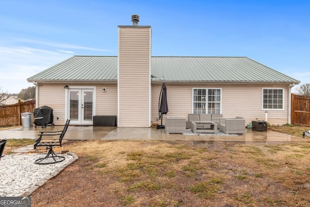 back of house with fence, french doors, metal roof, outdoor lounge area, and a patio area
