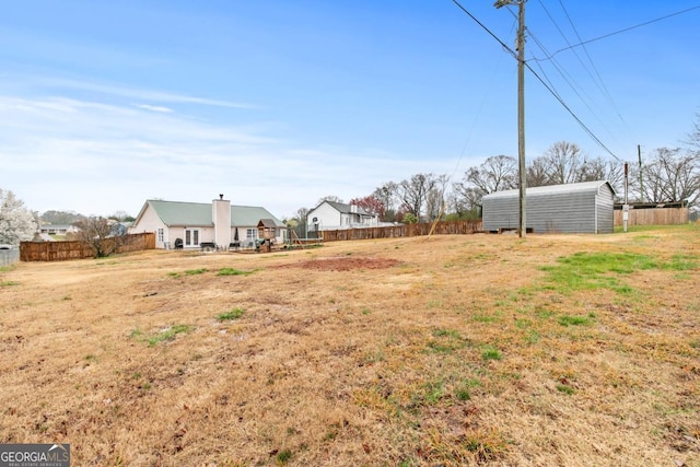 view of yard with an outbuilding and fence