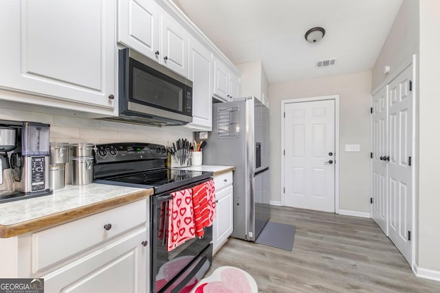 kitchen featuring visible vents, light countertops, light wood-style floors, appliances with stainless steel finishes, and white cabinetry