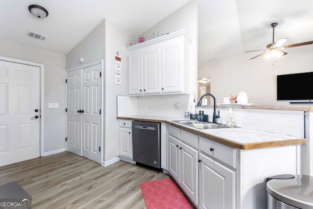 kitchen with visible vents, a sink, stainless steel dishwasher, a peninsula, and vaulted ceiling