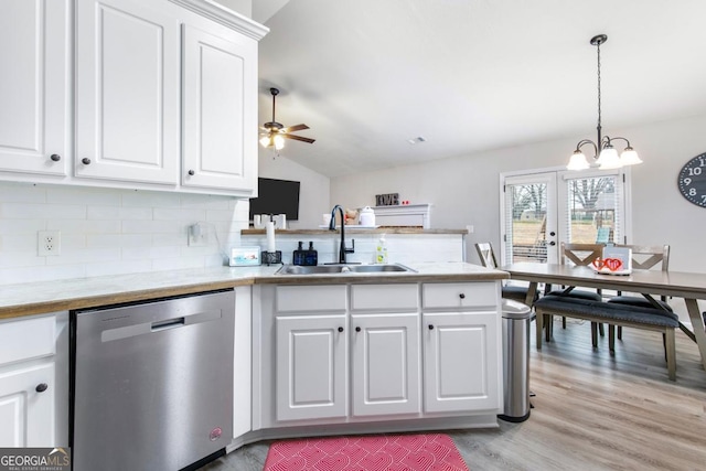 kitchen with a peninsula, a sink, vaulted ceiling, dishwasher, and light wood-type flooring
