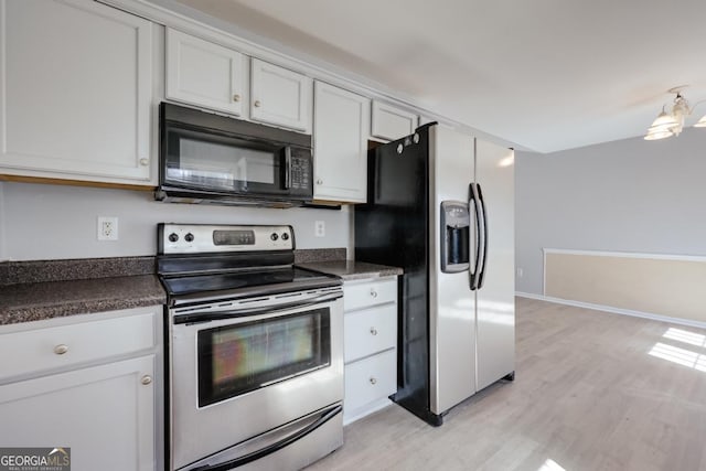 kitchen with light wood-type flooring, dark countertops, appliances with stainless steel finishes, and white cabinets