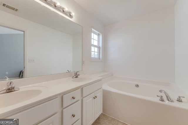 bathroom with double vanity, visible vents, a garden tub, and a sink