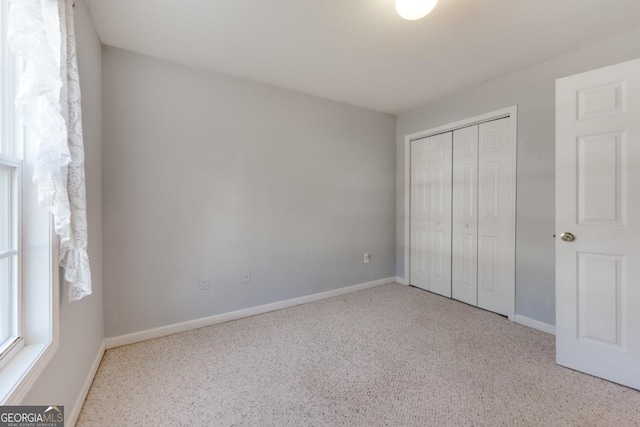 unfurnished bedroom featuring baseboards and a closet