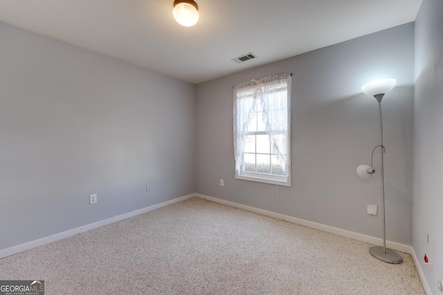 carpeted empty room with visible vents and baseboards