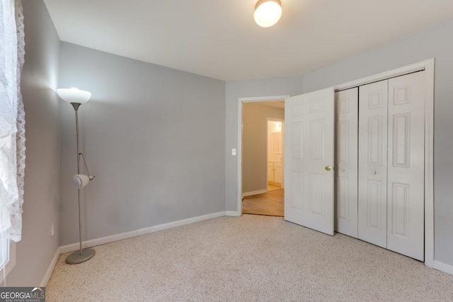 unfurnished bedroom with baseboards and a closet