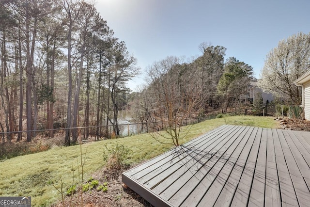 wooden terrace with a lawn and a fenced backyard