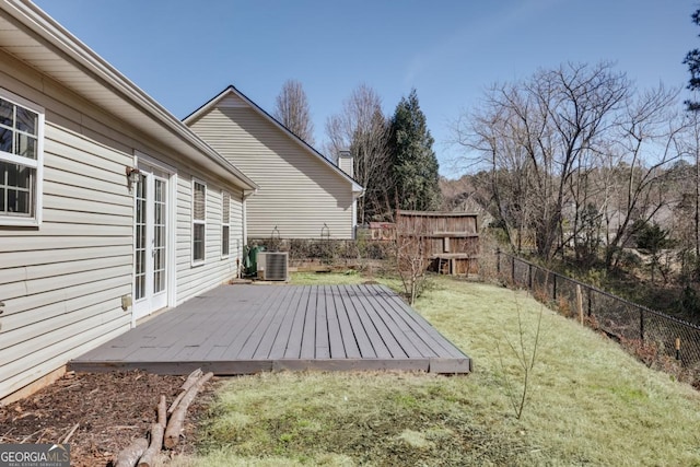 view of yard with central air condition unit, a wooden deck, and a fenced backyard