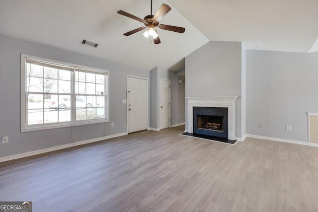 unfurnished living room featuring wood finished floors, visible vents, a fireplace, ceiling fan, and vaulted ceiling