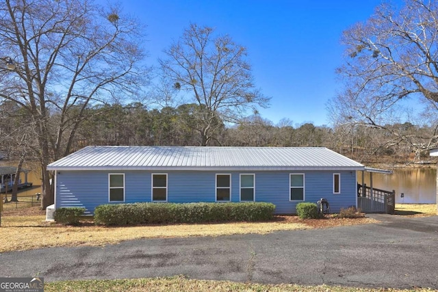 view of property exterior with metal roof and a water view