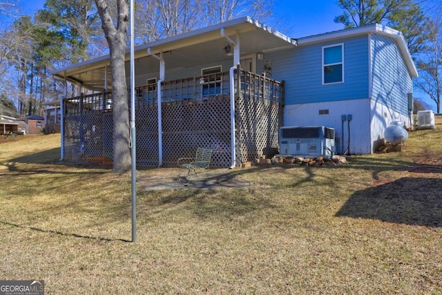 rear view of property featuring a yard and central AC unit