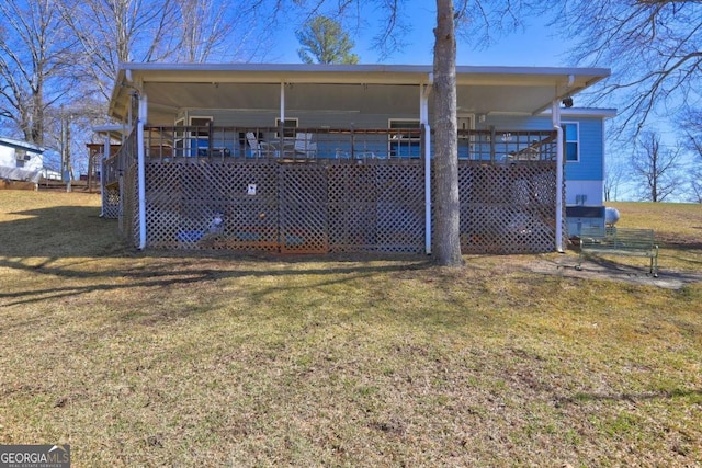 rear view of house with a yard and a wooden deck