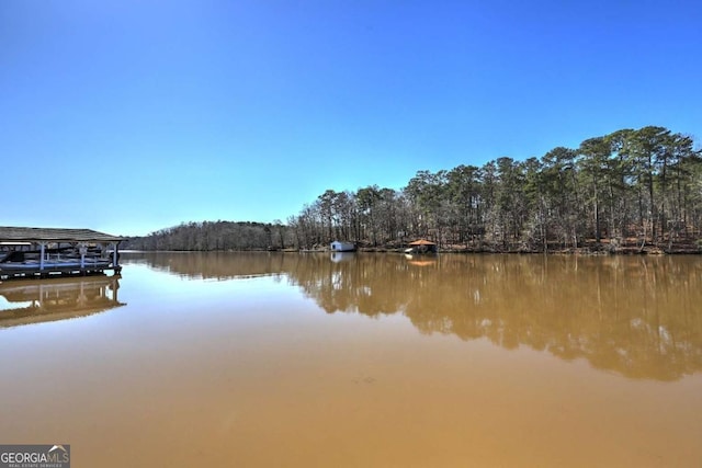 view of dock featuring a forest view and a water view