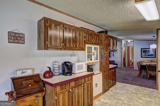 kitchen featuring crown molding, white microwave, and a textured ceiling