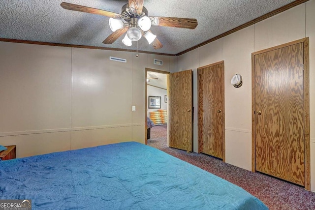 bedroom featuring visible vents, carpet, crown molding, and a textured ceiling