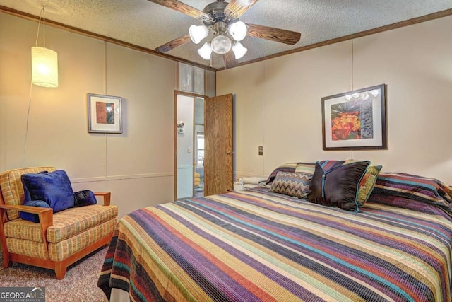 bedroom with a textured ceiling, ceiling fan, crown molding, and a decorative wall