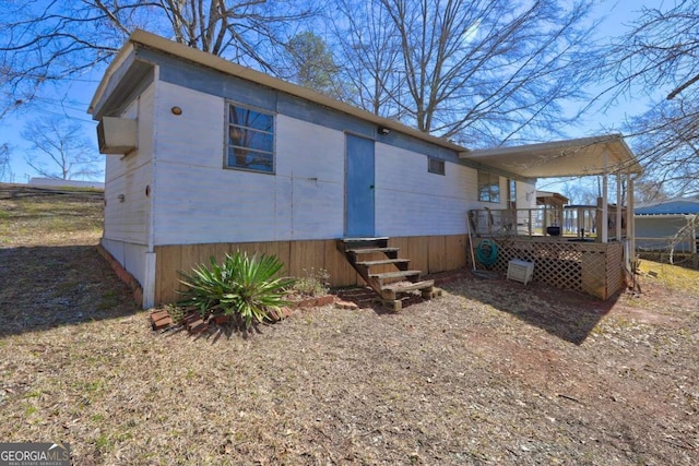 rear view of property featuring entry steps and a deck