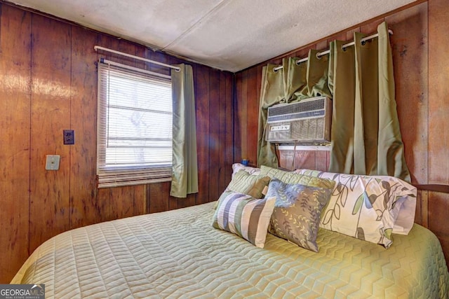 bedroom featuring wood walls and cooling unit