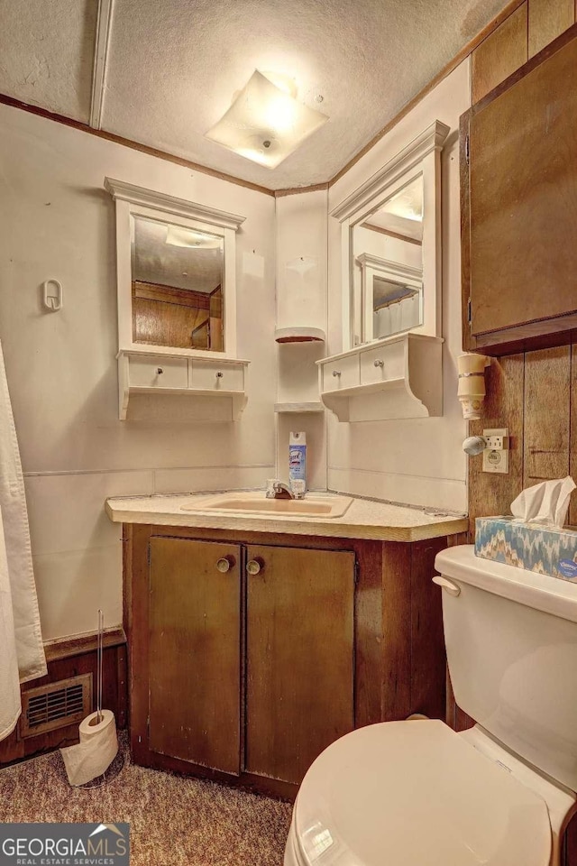 half bath featuring vanity, toilet, and visible vents