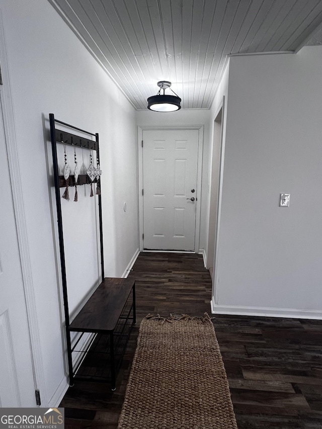 corridor featuring wood ceiling, baseboards, and wood finished floors