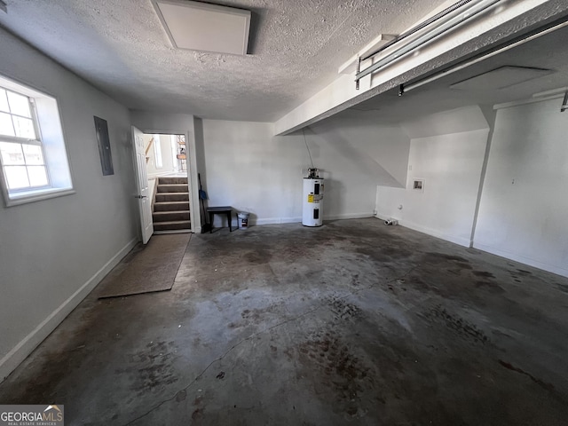 garage featuring baseboards and electric water heater