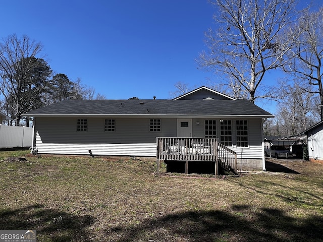 back of house featuring a yard, roof with shingles, a wooden deck, and fence