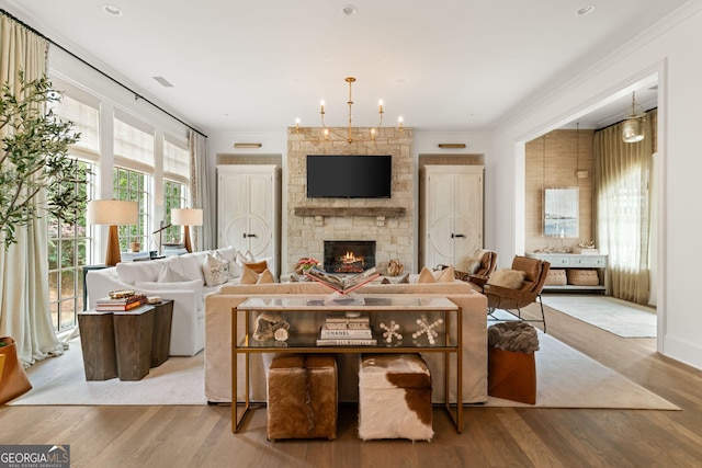 living area with wood finished floors, a fireplace, and crown molding