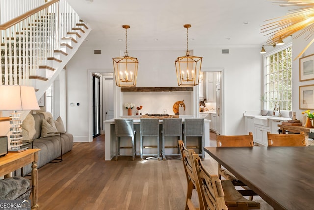 dining area with an inviting chandelier, wood finished floors, and visible vents