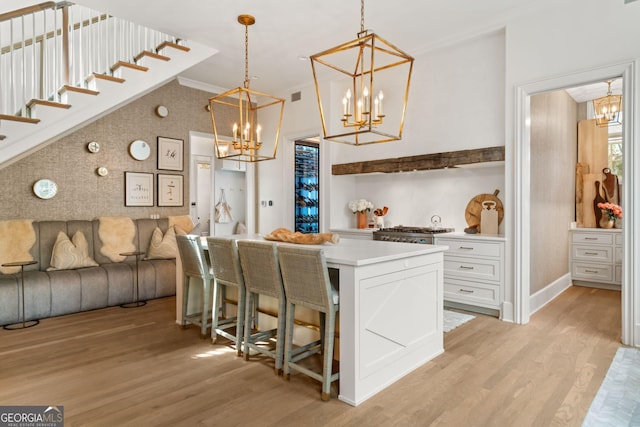 kitchen with a chandelier, white cabinets, light countertops, and light wood-style floors