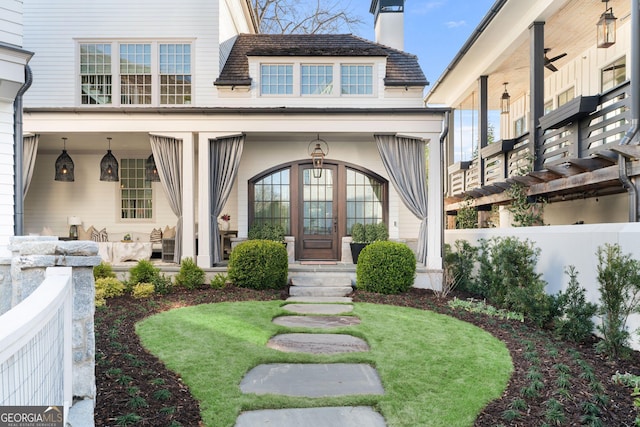 doorway to property with covered porch and a chimney