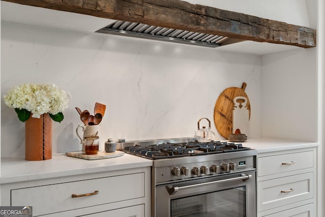 kitchen featuring stainless steel range, white cabinetry, and light countertops