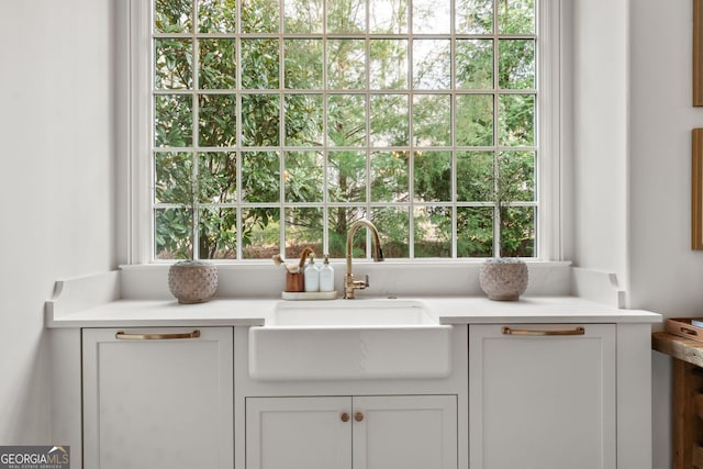 details with a sink, white cabinetry, and light countertops