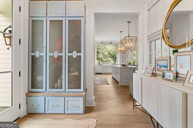 interior space with vanity, an inviting chandelier, and wood finished floors