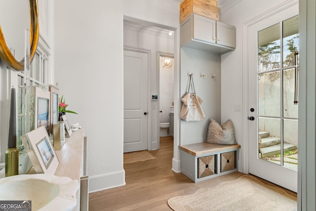 mudroom featuring baseboards, plenty of natural light, and light wood-style floors