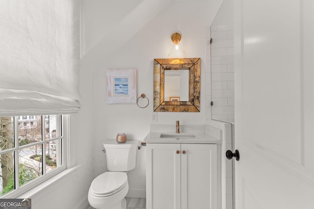 bathroom with toilet, vanity, and baseboards