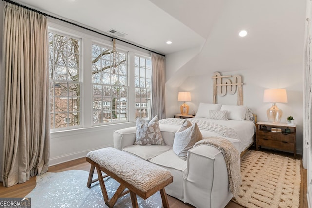 bedroom with recessed lighting, multiple windows, wood finished floors, and visible vents