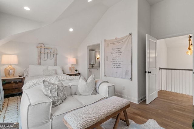 bedroom with wood finished floors, baseboards, ensuite bath, lofted ceiling, and recessed lighting