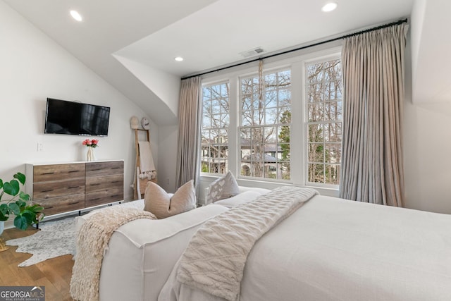 bedroom with vaulted ceiling, visible vents, recessed lighting, and wood finished floors