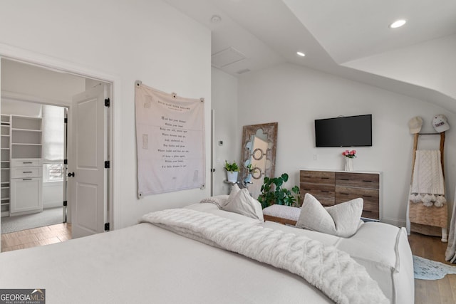 bedroom featuring vaulted ceiling, a spacious closet, recessed lighting, and light wood finished floors