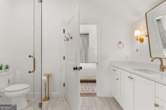 ensuite bathroom with vanity, toilet, and connected bathroom