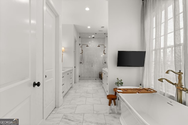 bathroom with a shower stall, recessed lighting, a soaking tub, marble finish floor, and vanity