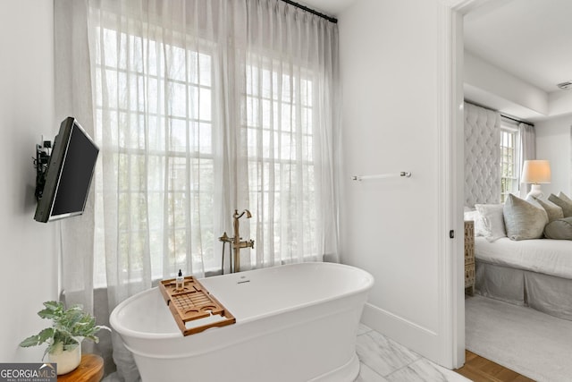 bathroom featuring visible vents, baseboards, and a freestanding bath