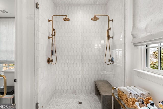 full bathroom with visible vents and tiled shower