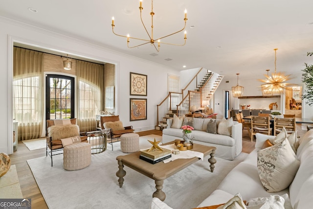 living room with stairway, ornamental molding, recessed lighting, light wood-style floors, and a notable chandelier