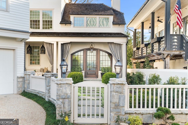 property entrance with fence, a porch, a chimney, a garage, and a gate