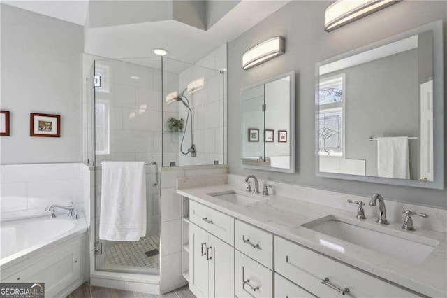 full bath with a shower stall, a garden tub, double vanity, and a sink