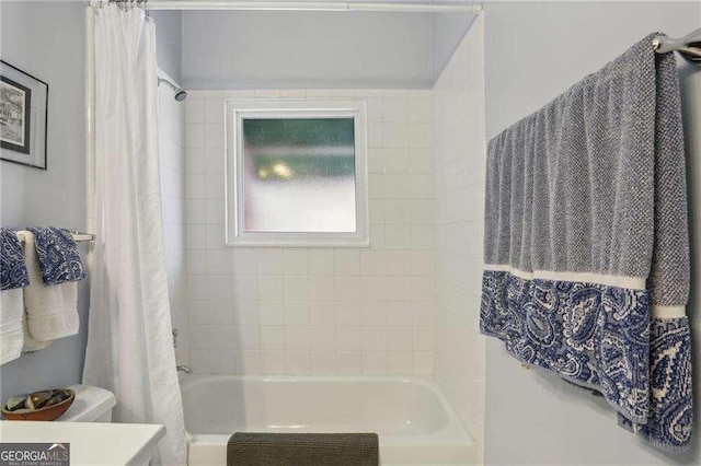 full bath with toilet and shower / tub combo with curtain