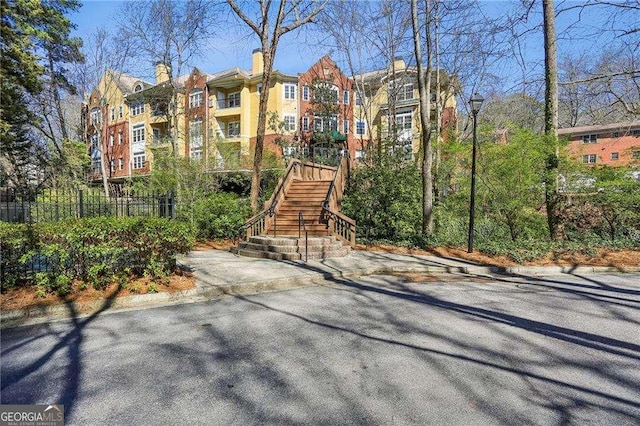 view of building exterior with stairs and fence